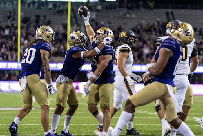 Washington Huskies defensive back Asa Turner (20), defensive back Kyler Gordon (2), second from left, celebrate after linebacker Ryan Bowman (55), center, recovered a California Golden Bears fumble.